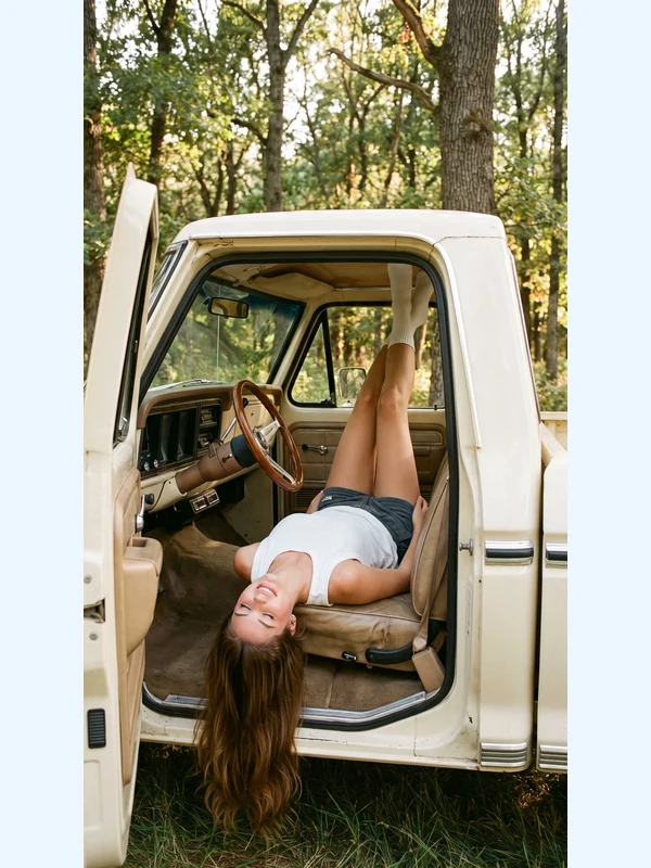 Adult woman reclining on a vintage truck seat